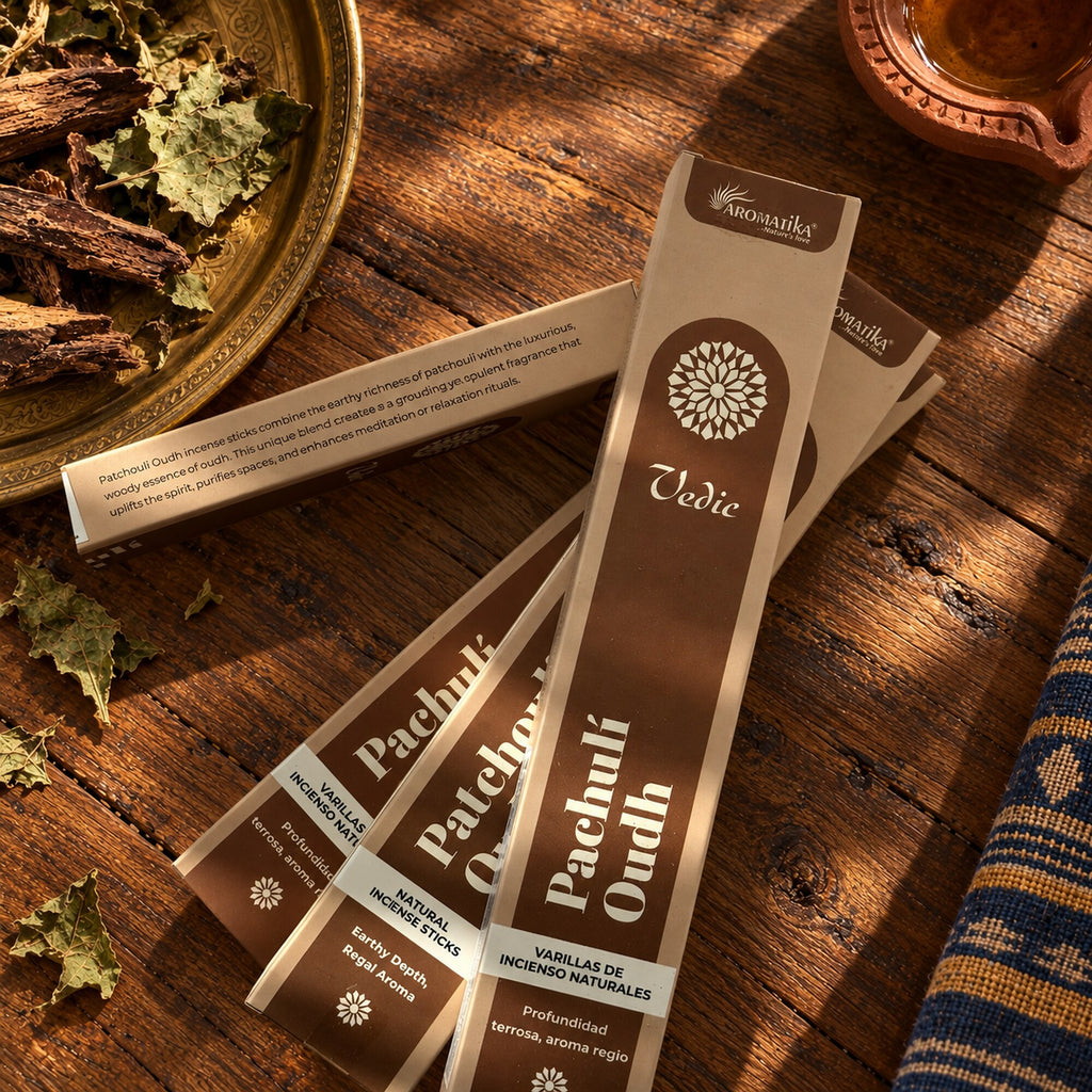 Aromatika Patchouli Oudh incense stick boxes arranged with dried herbs and wood on rustic table Ayurveda inspired bohemian setting 