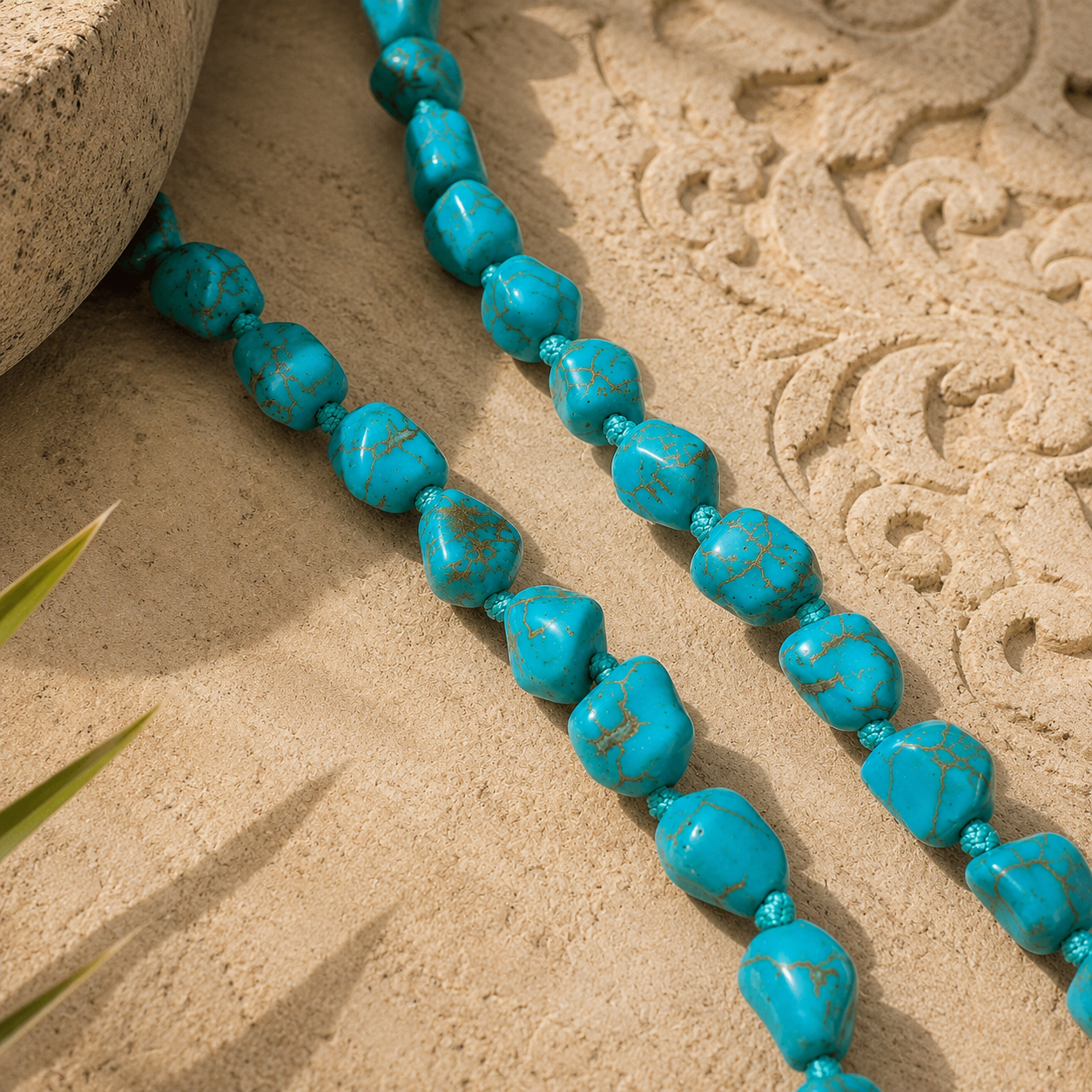Close-up of handmade irregular blue stone beads on a necklace against natural stone