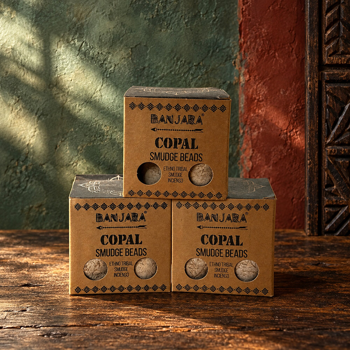 Banjara Copal Smudge Beads incense boxes displayed on a rustic wooden surface.