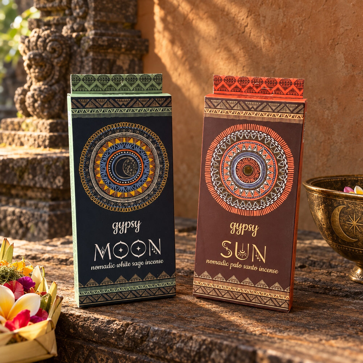 Gypsy Sun Palo Santo and Gypsy Moon White Sage nomadic incense packages displayed together in a warm Balinese ceremonial-inspired setting.