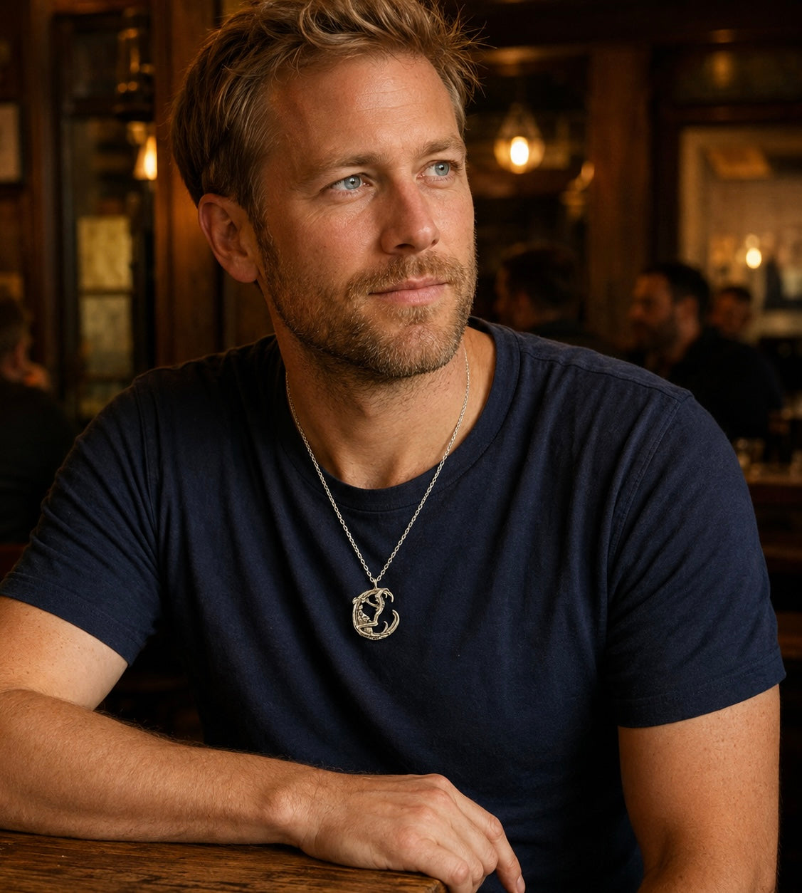 Man wearing a silver-tone moon pendant necklace with a dark casual T-shirt