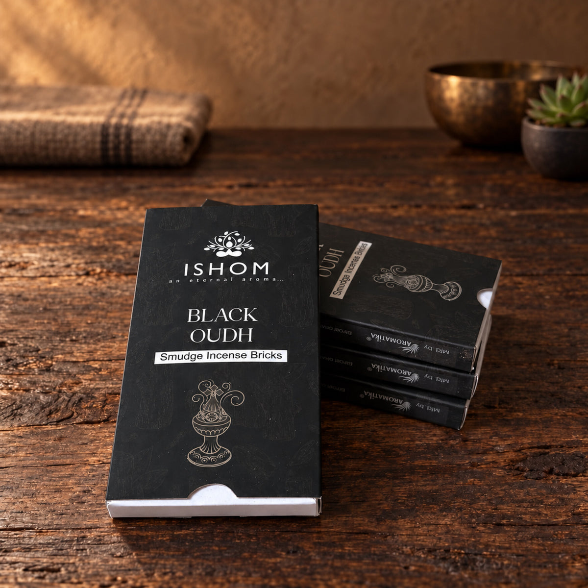 ISHOM Black Oudh smudge incense bricks boxed on rustic wooden surface