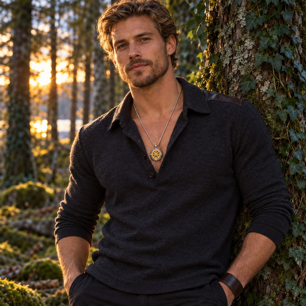 Man wearing a double-sided Nordic-inspired silver and gold compass pendant necklace in a forest setting.