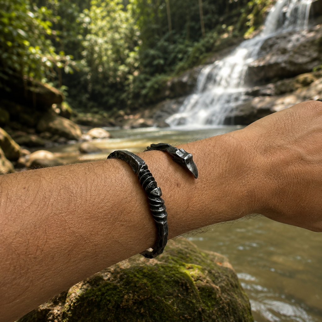 Nordic forged open cuff bracelet worn outdoors near a tropical waterfall.