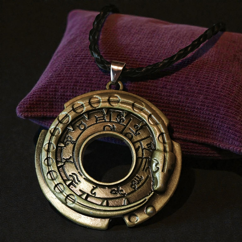 Close-up of a round gold-tone Norse-inspired rune snake wheel pendant on a black braided cord