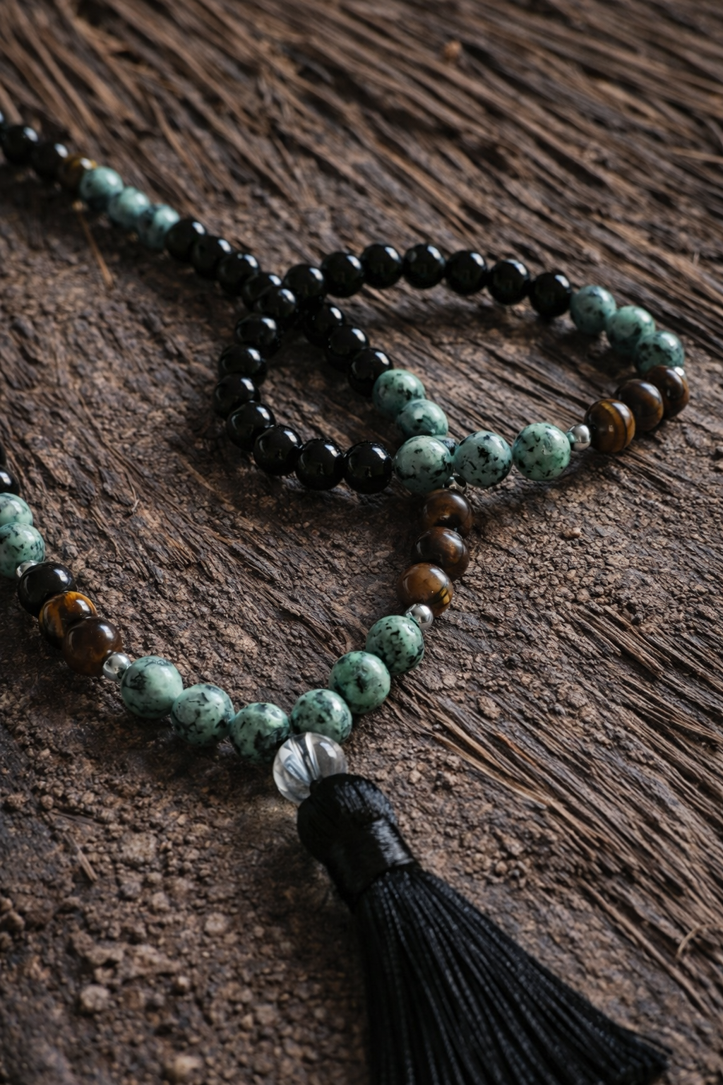 Boho earth bead necklace and bracelet set with tassel on rustic wooden background