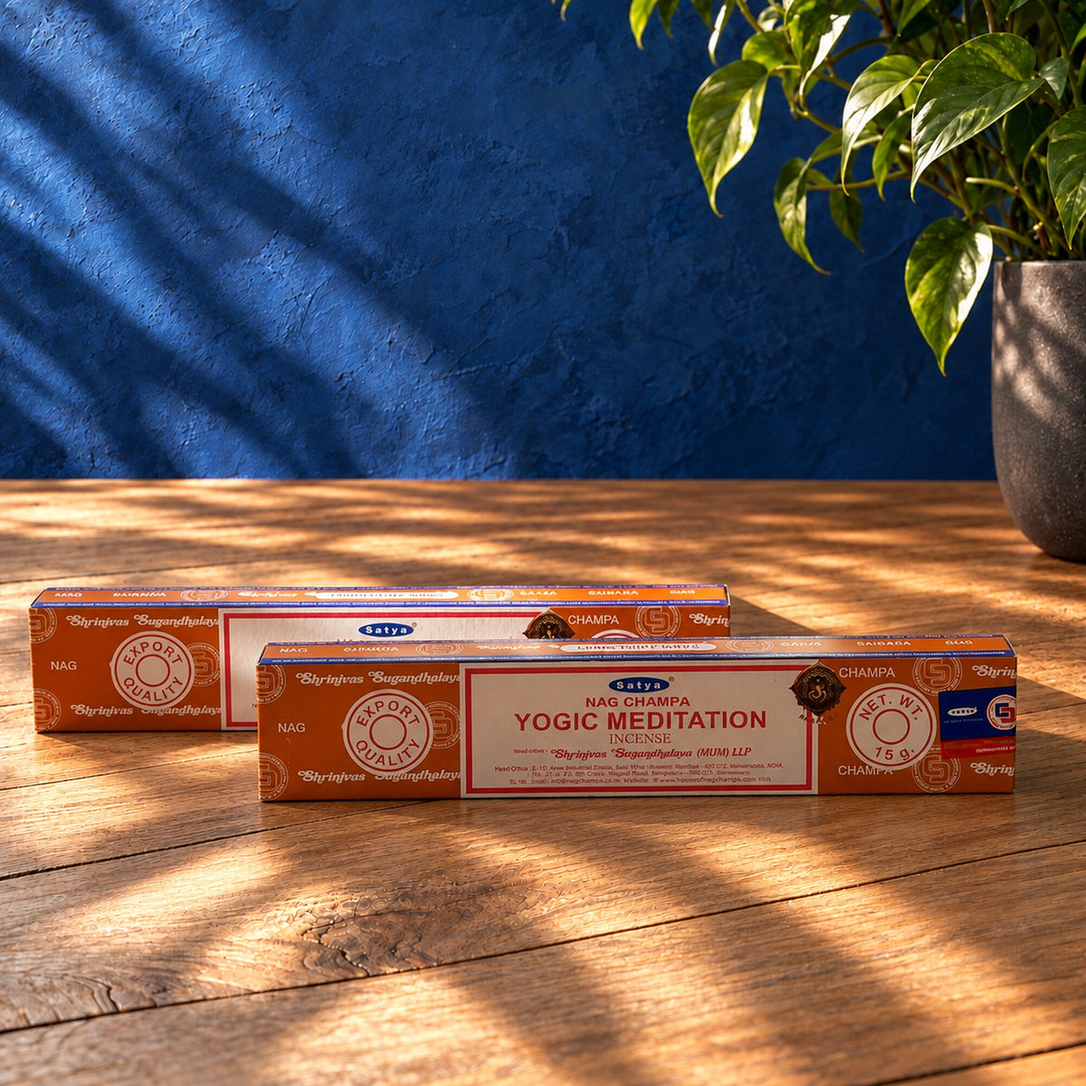 Two Satya Nag Champa Yogic Meditation incense stick boxes, 15g each, displayed on a wooden table in a sunlit yoga-inspired setting.