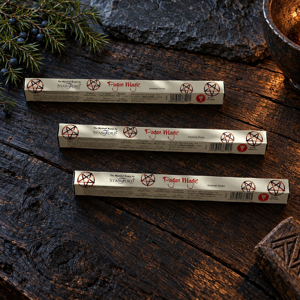 Stamford Pagan Magic Aphrodesia incense stick packs displayed on a dark rustic wooden surface with juniper branches.