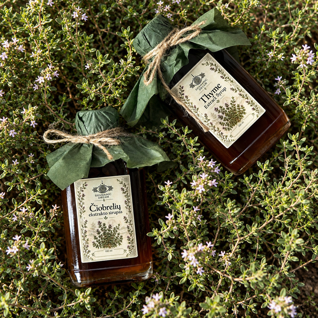 Shamanic Dream Thyme Extract Syrup 100 ml bottles photographed among flowering thyme plants